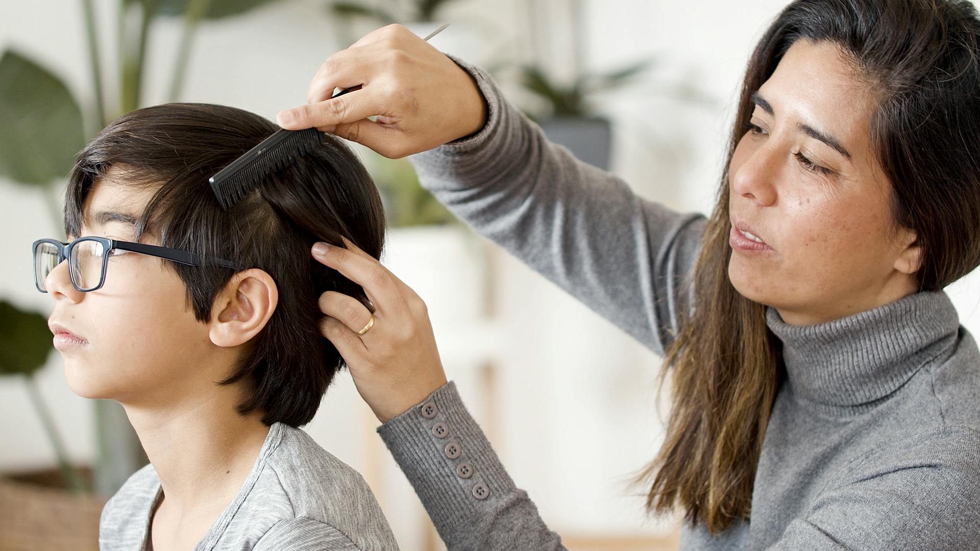 Mother combing child hair during lice check for Blair Nebraska families