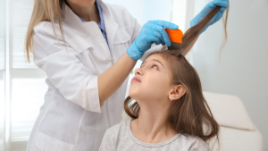 Parent inspecting child's hair with a fine-tooth lice comb during a clinic head check