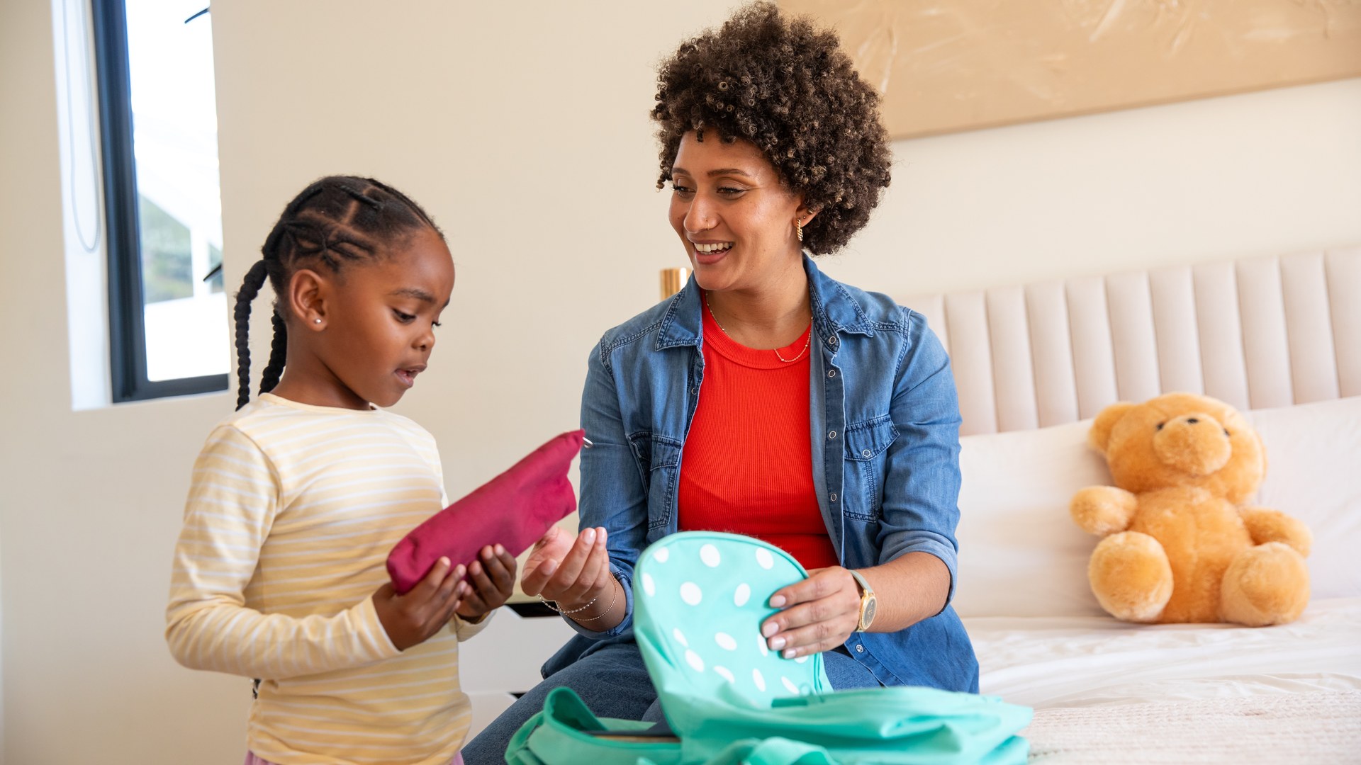 An Omaha mother and her young daughter pack a school backpack together on the bed as the new school year approaches, the moment a parent weighs how to protect a child from head lice and might reach for a peppermint prevention spray.